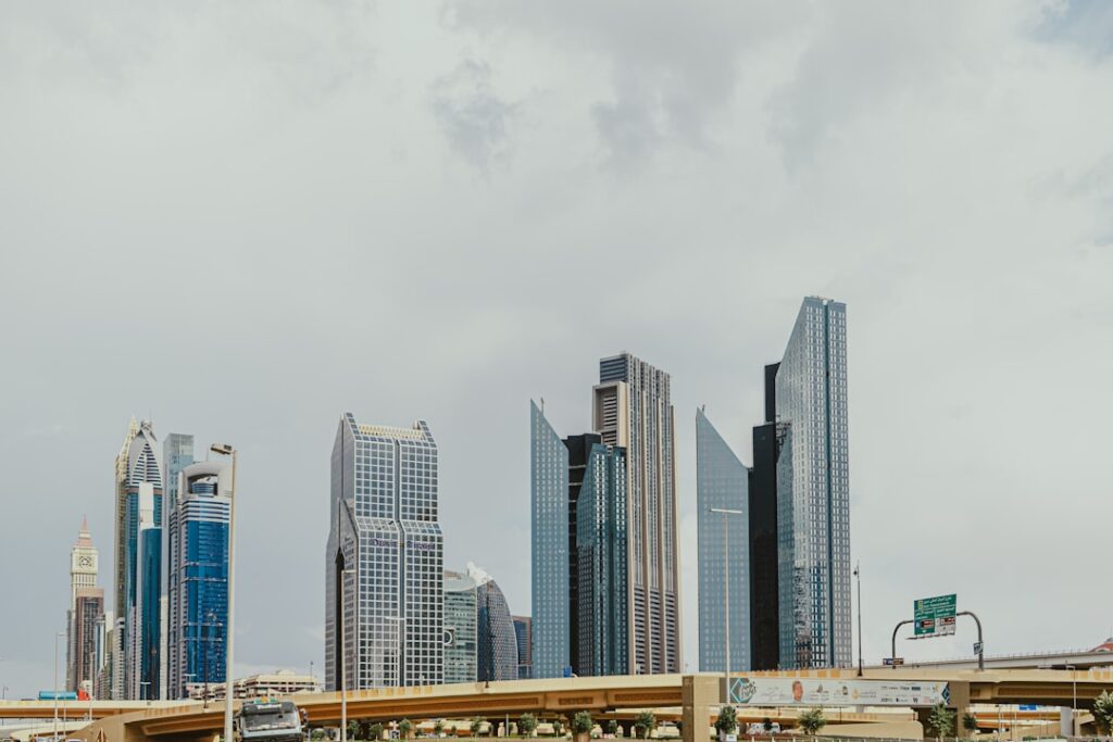Modern skyline in Financial district of Dubai downtown with unique skyscrapers under a cloudy sky and traffic bridge