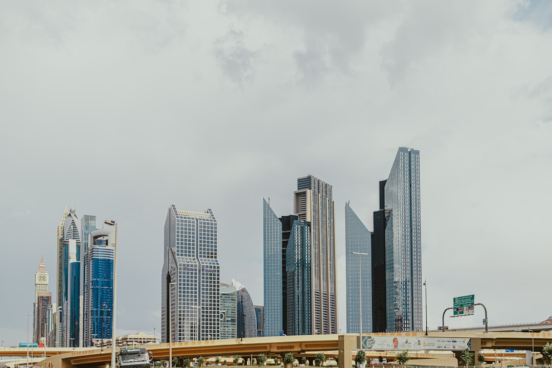 Modern skyline in Financial district of Dubai downtown with unique skyscrapers under a cloudy sky and traffic bridge