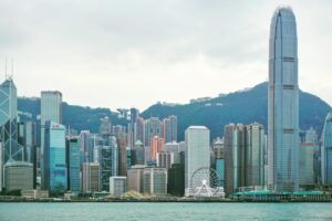 Modern city skyline with skyscrapers and mountains.
